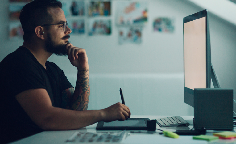 Man in a dark room looking at his computer